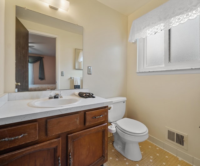 half bath featuring tile patterned floors, vanity, visible vents, and toilet