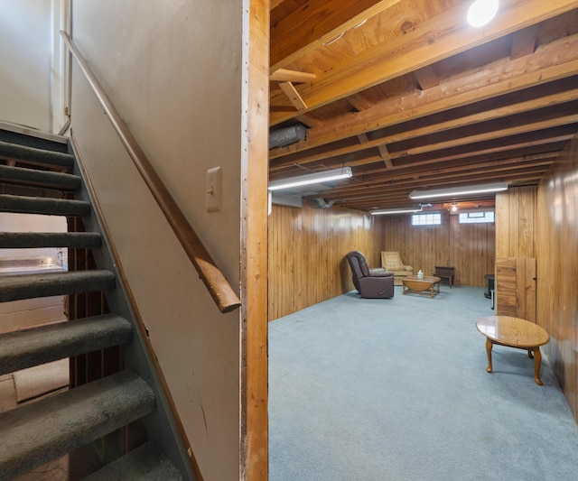 below grade area with stairway, wooden walls, and carpet floors