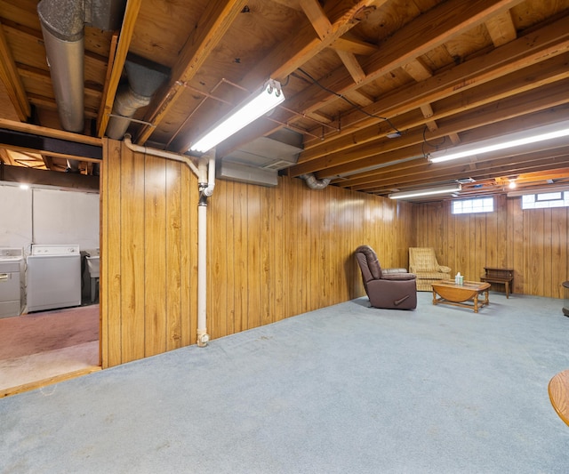 below grade area with wood walls, carpet, and washer and clothes dryer