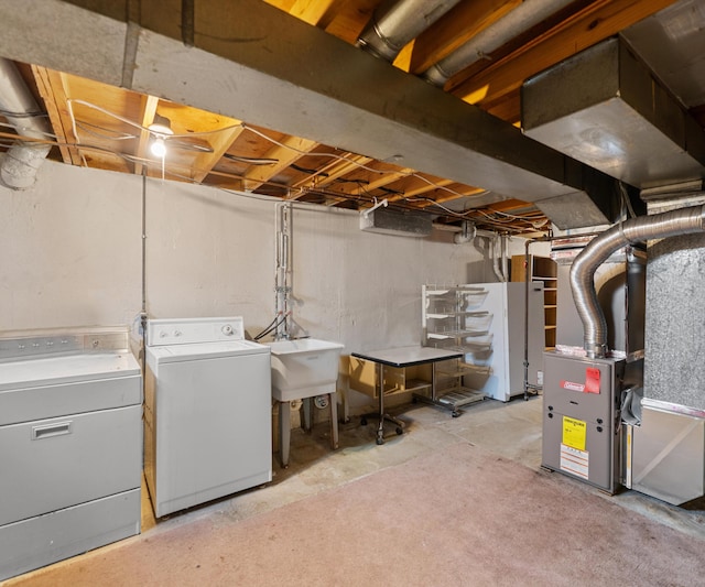 unfinished basement featuring independent washer and dryer, a sink, and heating unit