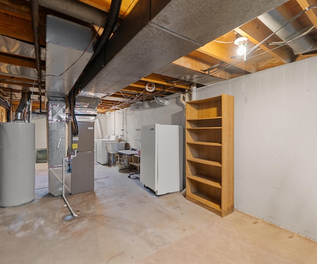unfinished basement featuring water heater, washer / dryer, freestanding refrigerator, and heating unit