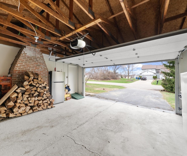 garage featuring a garage door opener and freestanding refrigerator