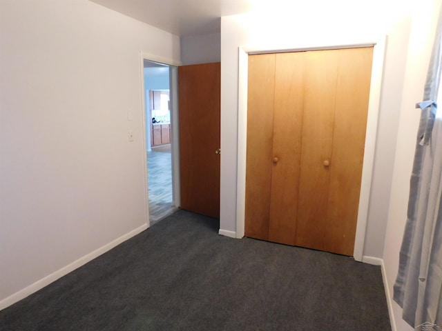 103 W Ludington Dr, Farwell, MI 48622 - unfurnished bedroom featuring dark colored carpet, baseboards, and a closet