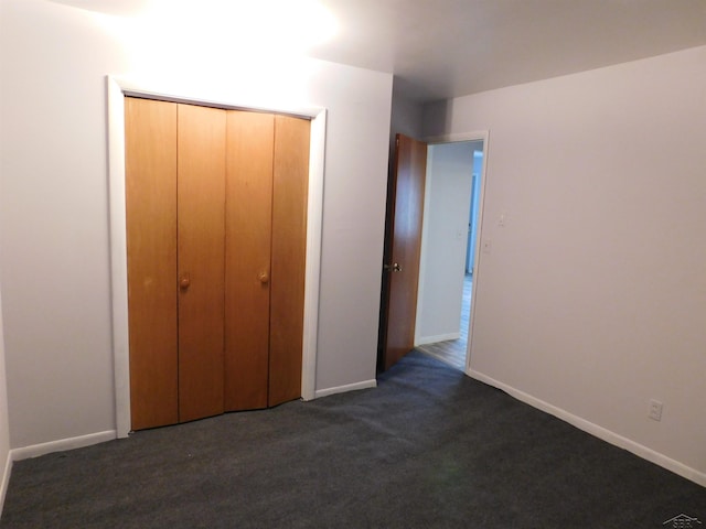 103 W Ludington Dr, Farwell, MI 48622 - unfurnished bedroom with dark carpet and baseboards