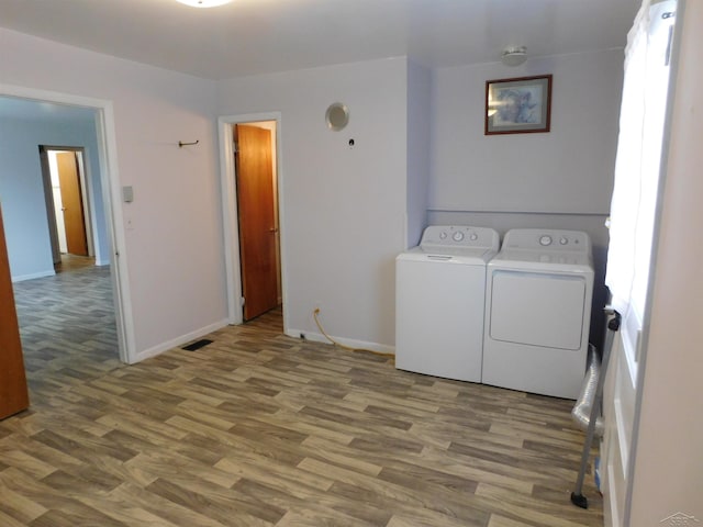 103 W Ludington Dr, Farwell, MI 48622 - laundry area featuring wood finished floors, baseboards, and washer and dryer