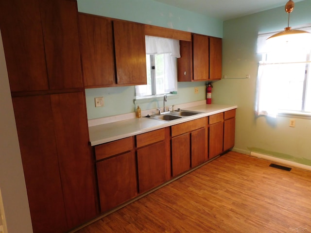 103 W Ludington Dr, Farwell, MI 48622 - kitchen with a sink, light countertops, brown cabinetry, and plenty of natural light