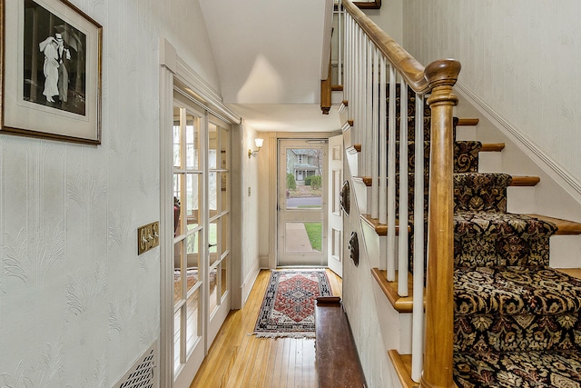interior space with light wood-style floors, visible vents, and stairs