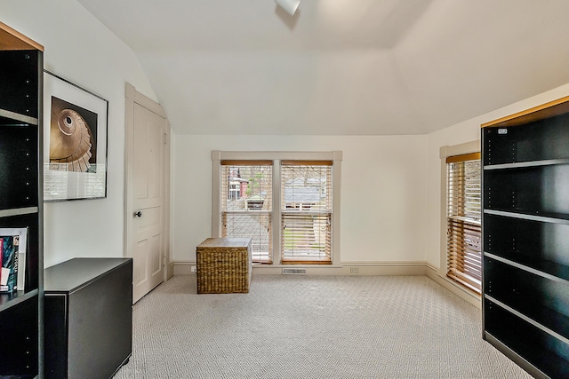 interior space with vaulted ceiling, visible vents, and carpet floors