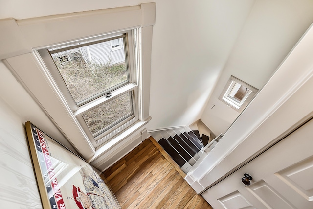 stairs with a towering ceiling and wood finished floors