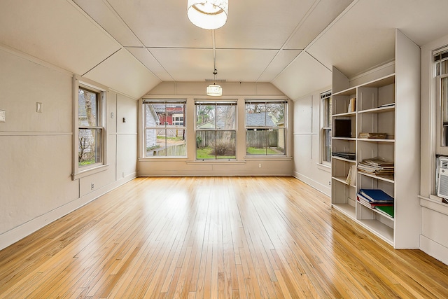 unfurnished dining area with hardwood / wood-style floors, vaulted ceiling, and baseboards