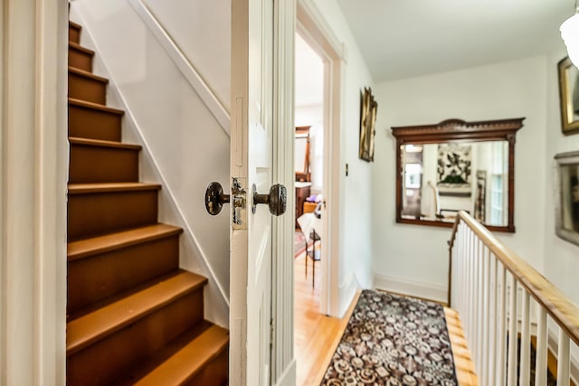 interior space featuring light wood-style floors, baseboards, and stairs