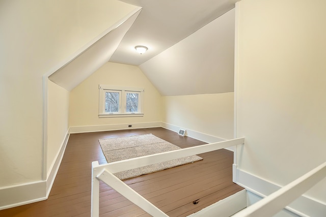 bonus room with hardwood / wood-style floors, baseboards, visible vents, and lofted ceiling