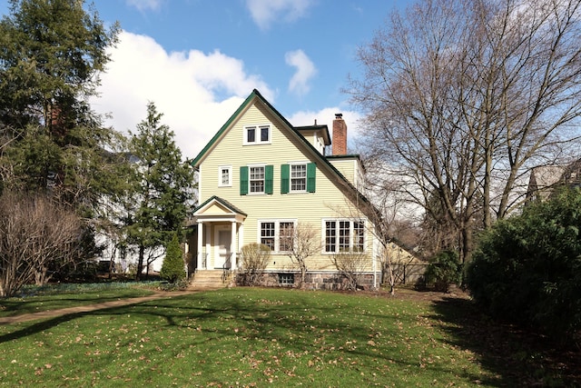 back of property featuring a lawn and a chimney