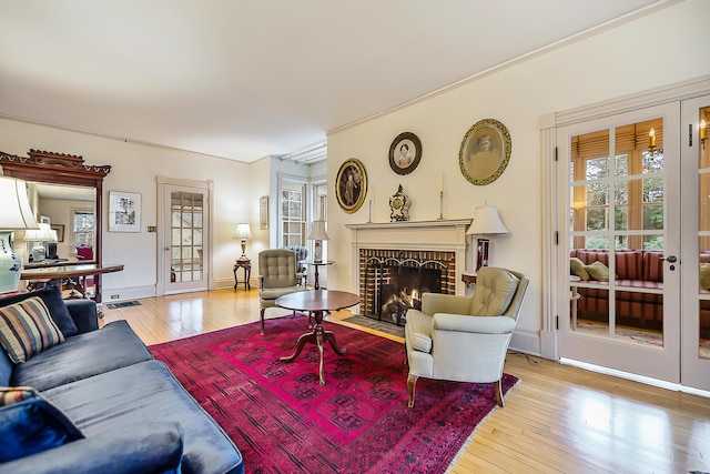 living room with a wealth of natural light, a brick fireplace, hardwood / wood-style floors, and visible vents