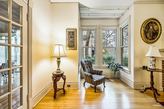 living area with light wood finished floors, baseboards, and beam ceiling
