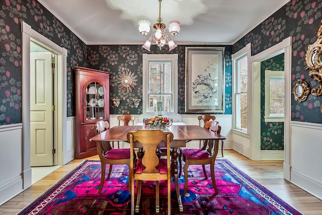 dining area featuring wallpapered walls, an inviting chandelier, and light wood-style floors