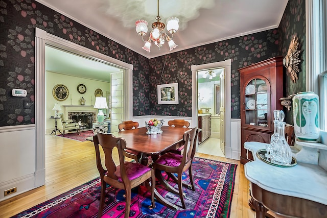 dining area with wallpapered walls and a wainscoted wall