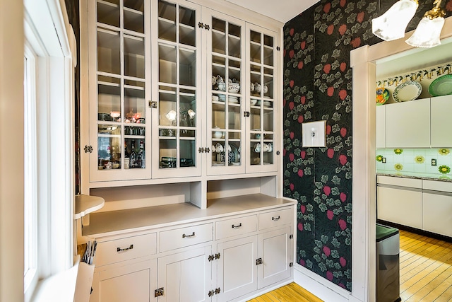 wine room featuring wallpapered walls and light wood-type flooring