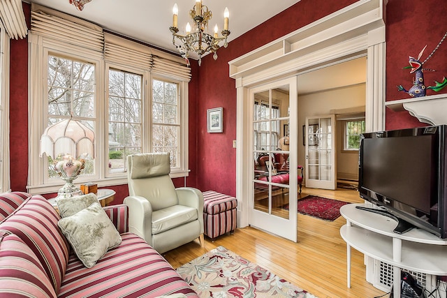 interior space with hardwood / wood-style floors, french doors, and a notable chandelier