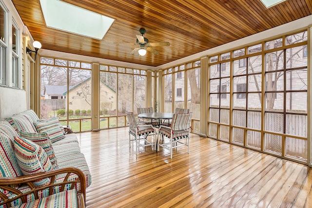 sunroom / solarium with wood ceiling, wood-type flooring, a deck, and a skylight