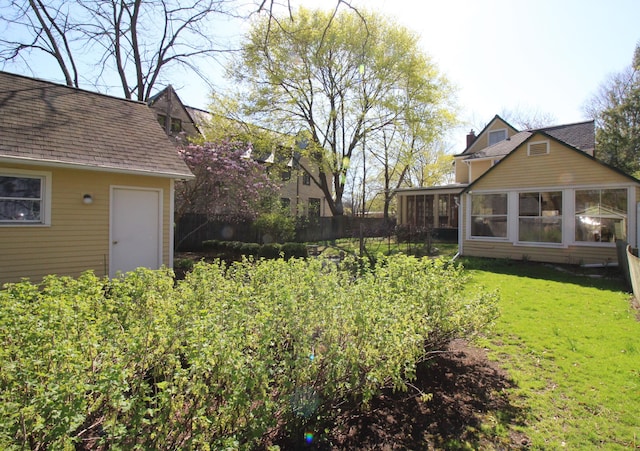 view of yard featuring fence and a sunroom