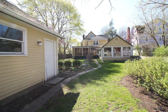 view of yard with a sunroom and fence