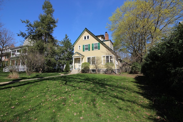 view of front facade featuring a front lawn and a chimney