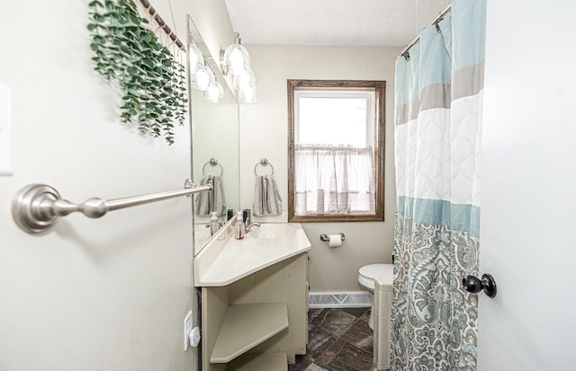 bathroom with curtained shower, vanity, baseboards, and toilet