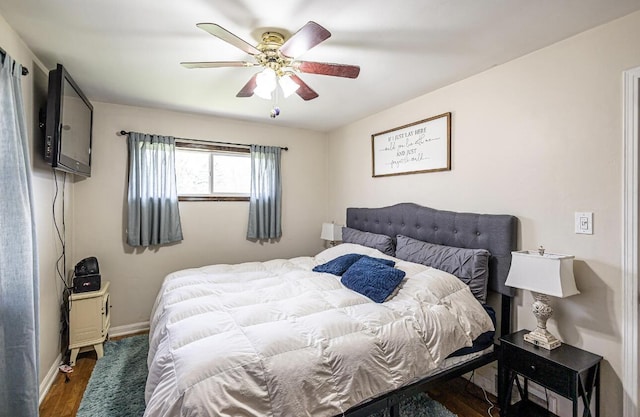 bedroom featuring ceiling fan, baseboards, and wood finished floors