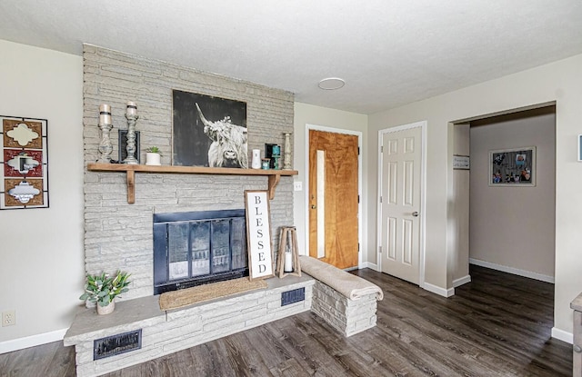unfurnished living room with visible vents, dark wood-style flooring, a fireplace, and baseboards