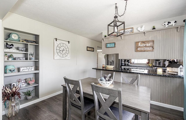 dining space with dark wood-type flooring, built in features, and a textured ceiling