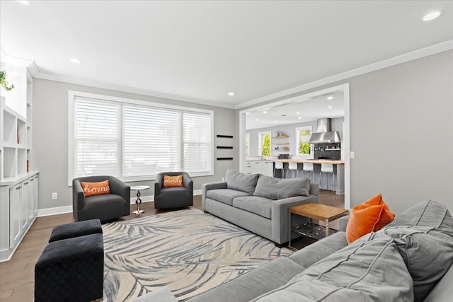 living room with crown molding, recessed lighting, and wood finished floors