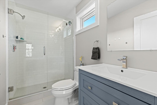 bathroom featuring vanity, toilet, tile patterned flooring, and a stall shower
