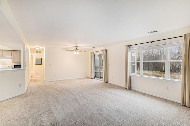 unfurnished living room with light carpet, visible vents, baseboards, and ceiling fan