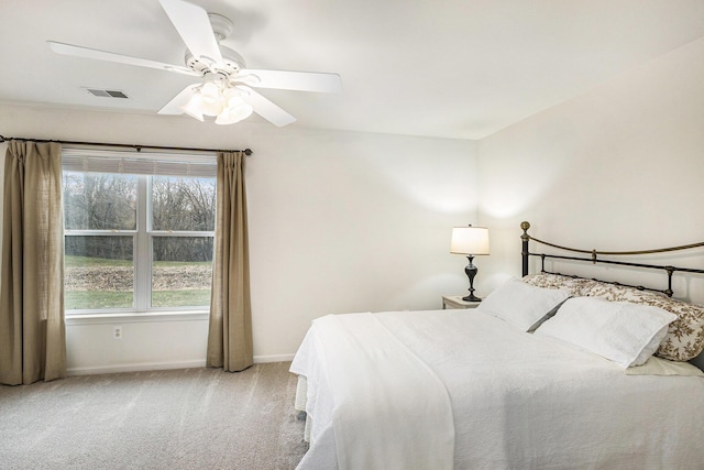 carpeted bedroom with baseboards, a ceiling fan, and visible vents