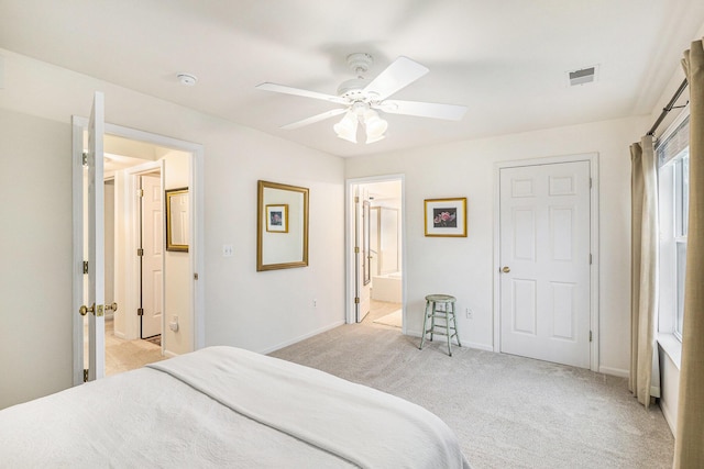 bedroom with ceiling fan, ensuite bathroom, light colored carpet, visible vents, and baseboards
