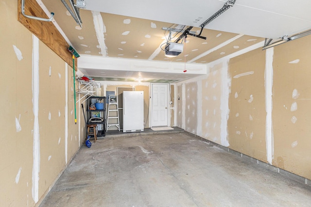 garage featuring a garage door opener and freestanding refrigerator