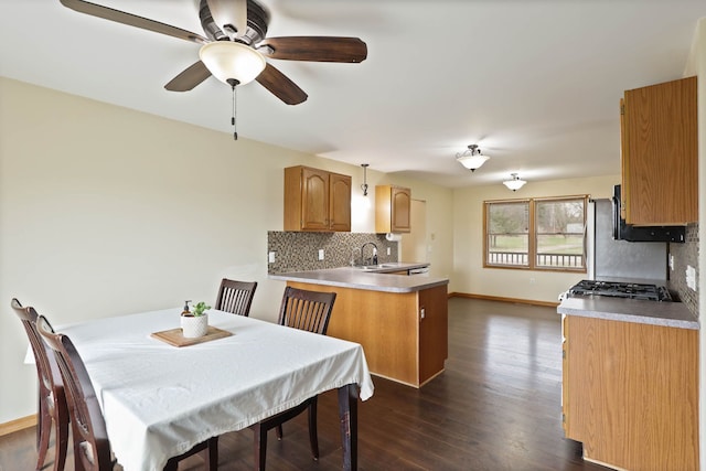 3353 Murphy Lake Rd, Millington, MI 48746 - kitchen featuring a peninsula, a ceiling fan, dark wood-style flooring, decorative backsplash, and baseboards