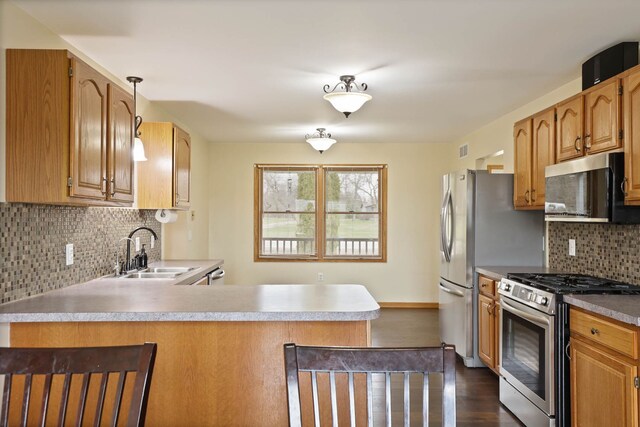 3353 Murphy Lake Rd, Millington, MI 48746 - kitchen featuring tasteful backsplash, dark wood-style flooring, a peninsula, stainless steel appliances, and a sink