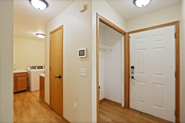 3353 Murphy Lake Rd, Millington, MI 48746 - hallway featuring light wood-style floors, a sink, baseboards, and washer / dryer