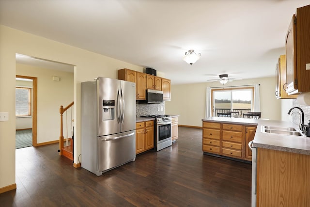 3353 Murphy Lake Rd, Millington, MI 48746 - kitchen with a sink, baseboards, a peninsula, and stainless steel appliances