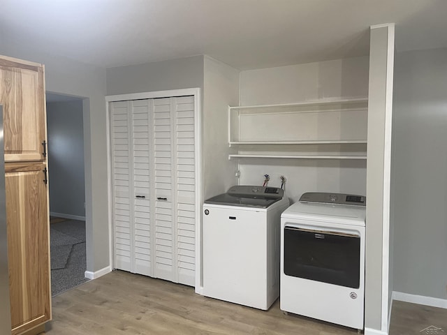 laundry room with baseboards, light wood-style flooring, laundry area, and washing machine and clothes dryer