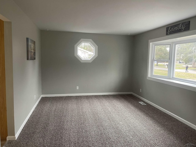 carpeted spare room featuring visible vents and baseboards
