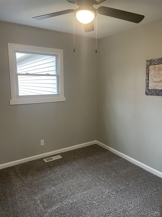 carpeted spare room with visible vents, baseboards, and ceiling fan