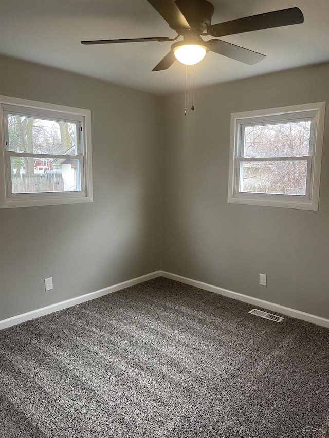 spare room with visible vents, ceiling fan, carpet flooring, and baseboards