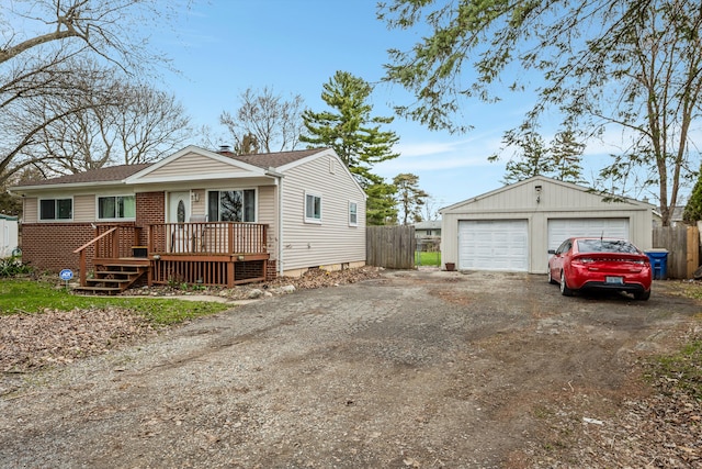 view of front of house featuring an outbuilding, a detached garage, and fence