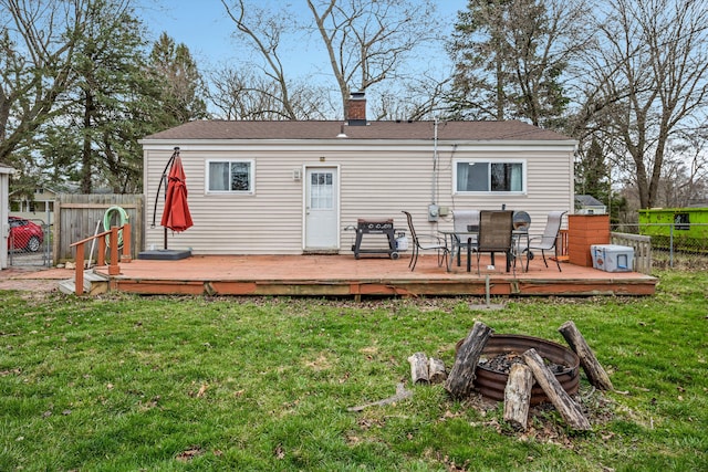 back of house with a yard, fence, and a chimney