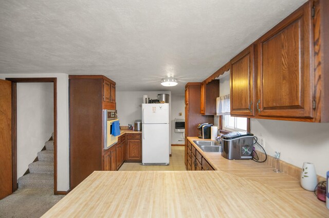 69465 High St, Union, MI 49130 - kitchen featuring white appliances, light countertops, brown cabinetry, and a sink