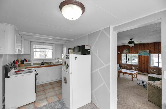 69465 High St, Union, MI 49130 - kitchen featuring white appliances, wood walls, healthy amount of natural light, white cabinets, and ceiling fan
