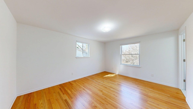 spare room with light wood-type flooring and baseboards